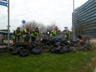 volunteer team by Ashford International Station with bags of rubbish and bicycles collected
