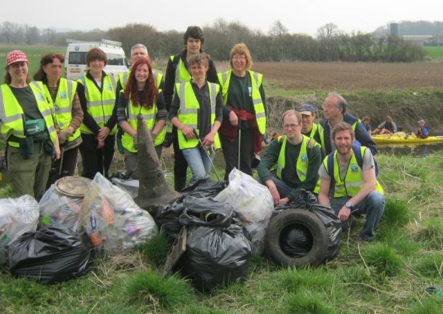 volunteers with bags of litter collected
