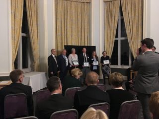 Rachel Green & group holding award certificates.