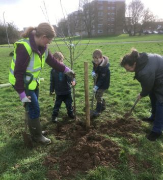 tree planters with children helping